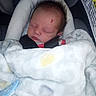 newborn, baby, sleeping, blanket, car_seat, pacifier, infant, face, child, cozy, indoor, resting, soft, cute, bundle, portrait, person, clothing, screenshot, mobile_screen