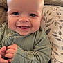 Liam is registered to the contest to win money with this photo: baby, smiling, infant, clothing, green_outfit, face, hands, cushion, blanket, indoor, happy, cute, child, portrait, sitting, ribbed_fabric, closeup, skin, person, cozy