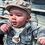 baby, blurred_background, cap, chubby_cheeks, close_up, clothing_store, cute, hand, hat, indoor, infant, jacket, pacifier, plush_jacket, portrait, sitting, skin, smiling, store_shelves, toddler