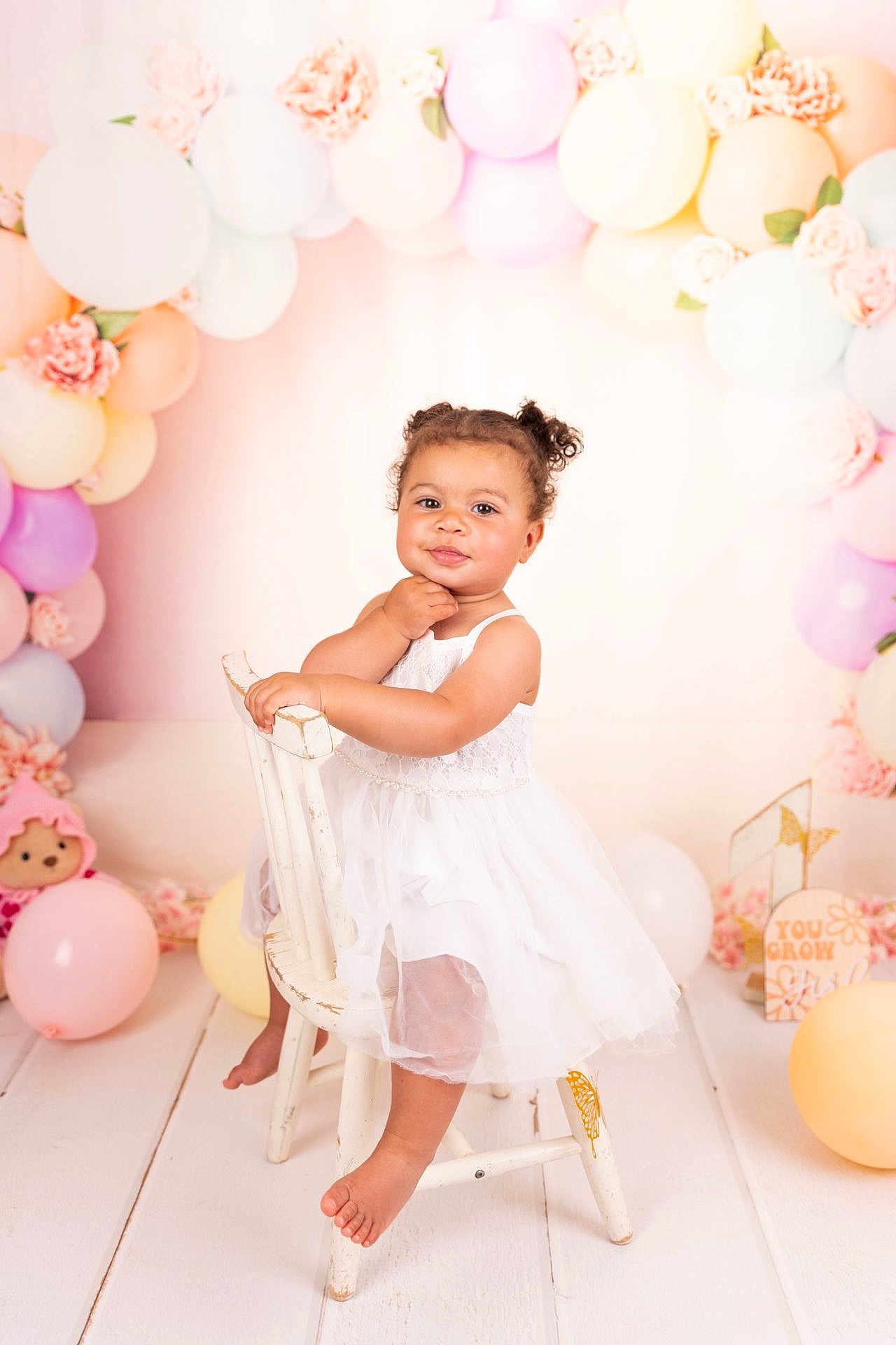 Tiyana a rejoint le concours — aidez-le/la à gagner de superbes lots ! baby, balloons, celebration, chair, child, cute, decorations, floor, flowers, indoor, pastel_colors, photo_shoot, pink, portrait, purple, smiling, toddler, toy, white_dress, yellow