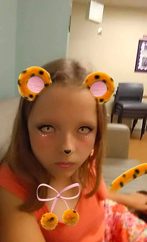 Lexi is registered to the contest to win money with this photo: child, ear, hair_accessory, head, headband, neck, party_supply, person, skin, smile, toddler, yellow