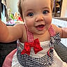baby, child, smile, face, blue_eyes, dress, bow, red, white, blue, indoor, person, cute, happy, young, closeup, infant, sitting, apparel, portrait