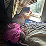 Mila is registered to the contest to win money with this photo: dog, diaper, pink_clothing, bed, window, curtain, tongue_out, sunlight, indoor, pet, brown_dog, resting, cozy, looking_out_window, furniture, fabric, relaxed, animal, domestic, home