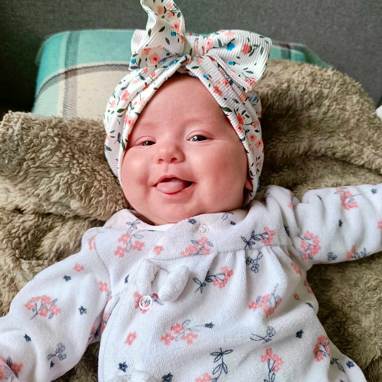 Cataleya participe au concours pour gagner de l'argent avec cette photo : adorable, baby, baby_girl, blanket, child, closeup, clothing, cozy, cute, face, floral_pattern, happy, headwrap, indoor, infant, laying_down, portrait, smiling, soft_texture, tongue_out