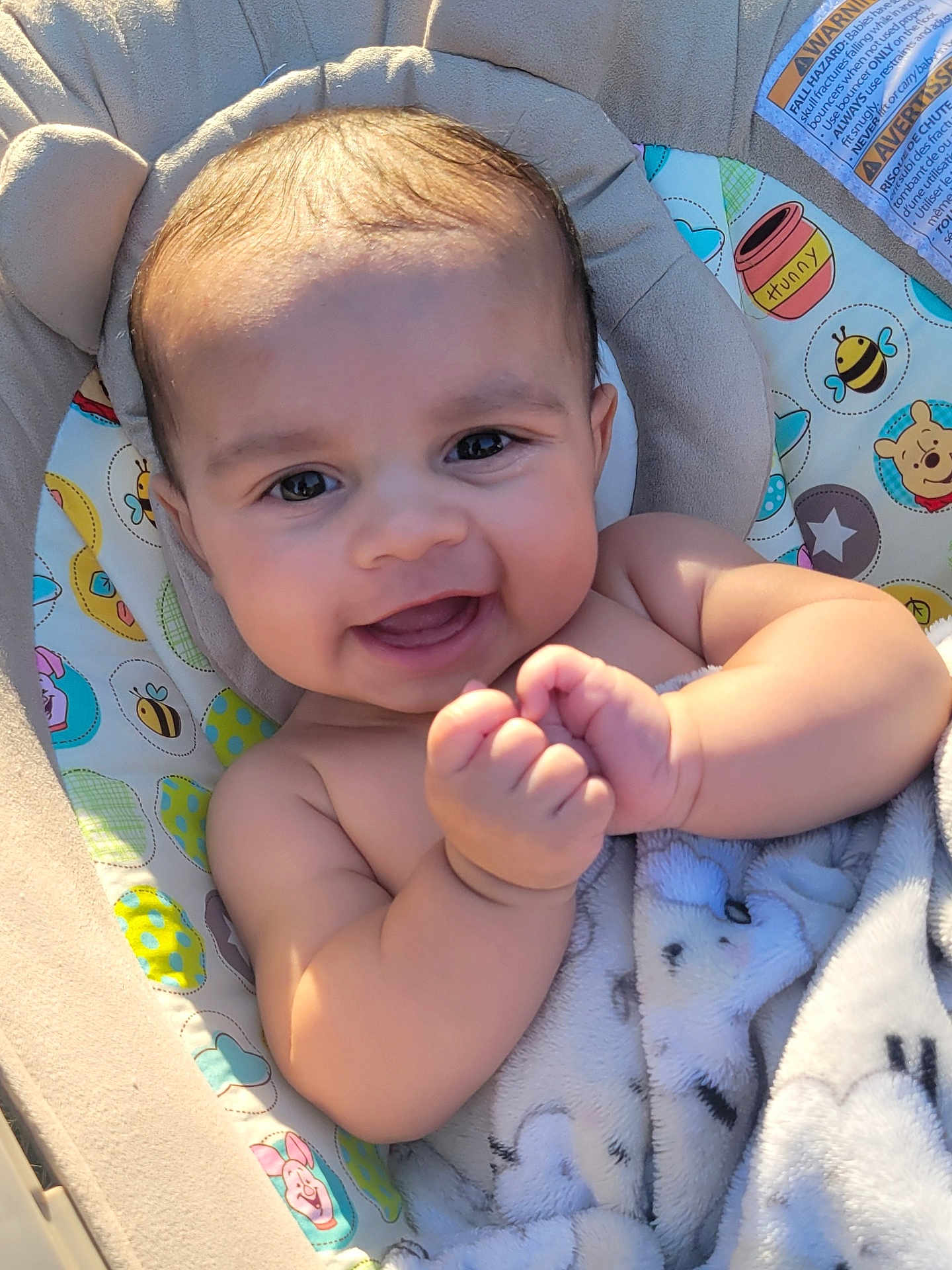 Brent is registered to the contest to win money with this photo: baby, smiling, infant, blanket, baby_seat, cute, happy, chubby_cheeks, sunlight, cartoon_pattern, soft_texture, wrapped, indoors, portrait, closeup, skin, face, hand, child, comfort