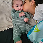 Brent is registered to the contest to win money with this photo: baby, child, kiss, bed, blanket, pillow, cozy, indoor, family, affection, toddler, sleepwear, cute, love, portrait, people, sibling, comfort, cuddling, skin