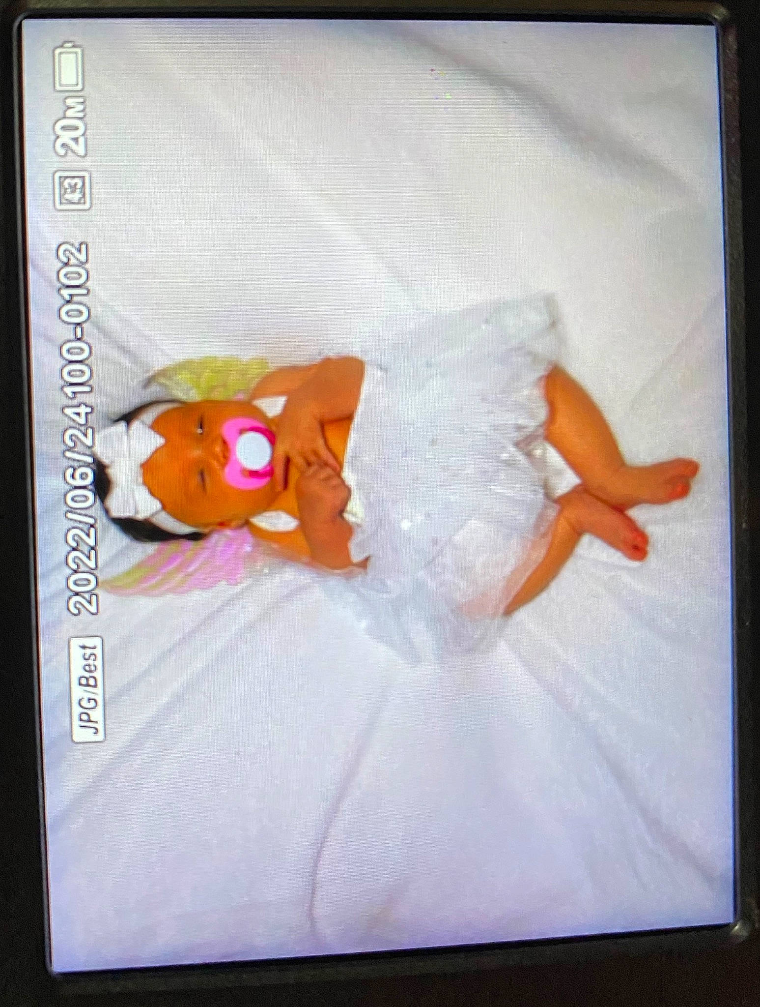 Elianna is registered to the contest to win money with this photo: art, baby_toddler_clothing, display_device, dress, electronic_device, embellishment, event, flat_panel_display, gadget, headwear, linens, magenta, multimedia, paper, peach, person, pink, rectangle, room, technology
