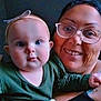 baby, child, woman, glasses, headband, smile, portrait, closeup, indoor, person, face, holding, cute, young_child, adult, apparel, green_clothing, happy, family, people