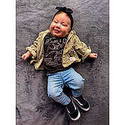 Billy-Ellen is registered to the contest to win money with this photo: baby, child, smiling, headband, jacket, tshirt, jeans, sneakers, lying_down, gray_background, cute, portrait, infant, happy, clothing, casual, indoor, person, fashion, young