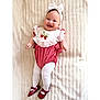baby, smiling, headband, bow, red_shoes, white_tights, strawberry_embroidery, red_and_white_outfit, infant, blanket, cute, happy, portrait, child, lying_down, soft_texture, fashion, adorable, young, indoors