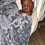 baby, sleeping, blanket, baby_seat, indoor, cozy, resting, child, infant, soft_texture, wood_floor, peaceful, cute, comfort, head, face, hand, closed_eyes, toddler, home