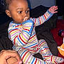Tymaree Johnson joined the competition — help win amazing prizes! baby, child, pacifier, striped_clothing, onesie, sitting, hand, indoor, person, cute, infant, young_child, colorful, comfort, bed, blanket, skin, face, expression, reaching