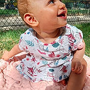 Laya a rejoint le concours — aidez-le/la à gagner de superbes lots ! baby, child, smiling, sitting, outdoor, grass, blanket, dress, happy, face, head, person, nature, sunlight, skin, ear, hand, foot, fence, park