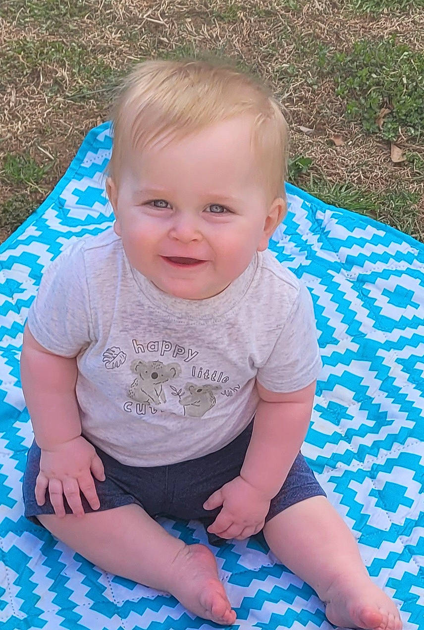 Landon is registered to the contest to win money with this photo: azure, baby, baby_toddler_clothing, blue, child, eye, fun, grass, grass_family, happy, head, iris, joy, leaf, leisure, pattern, person, plant, skin, smile