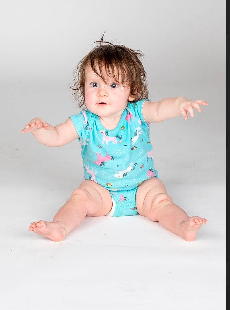 Harper is registered to the contest to win money with this photo: baby, baby_toddler_clothing, barefoot, cheek, collar, dress, eye, face, finger, foot, happy, human_body, human_leg, knee, person, pink, skin, sleeve, thigh, thumb