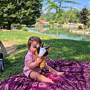 Lola participe au concours pour gagner de l'argent avec cette photo : baby, blanket, child, cute, daytime, grass, lake, nature, outdoor, park, playful, plush_toy, purple_blanket, sitting, smile, summer, sunlight, toddler, toy, tree
