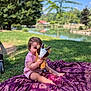 baby, blanket, child, cute, daytime, grass, lake, nature, outdoor, park, playful, plush_toy, purple_blanket, sitting, smile, summer, sunlight, toddler, toy, tree