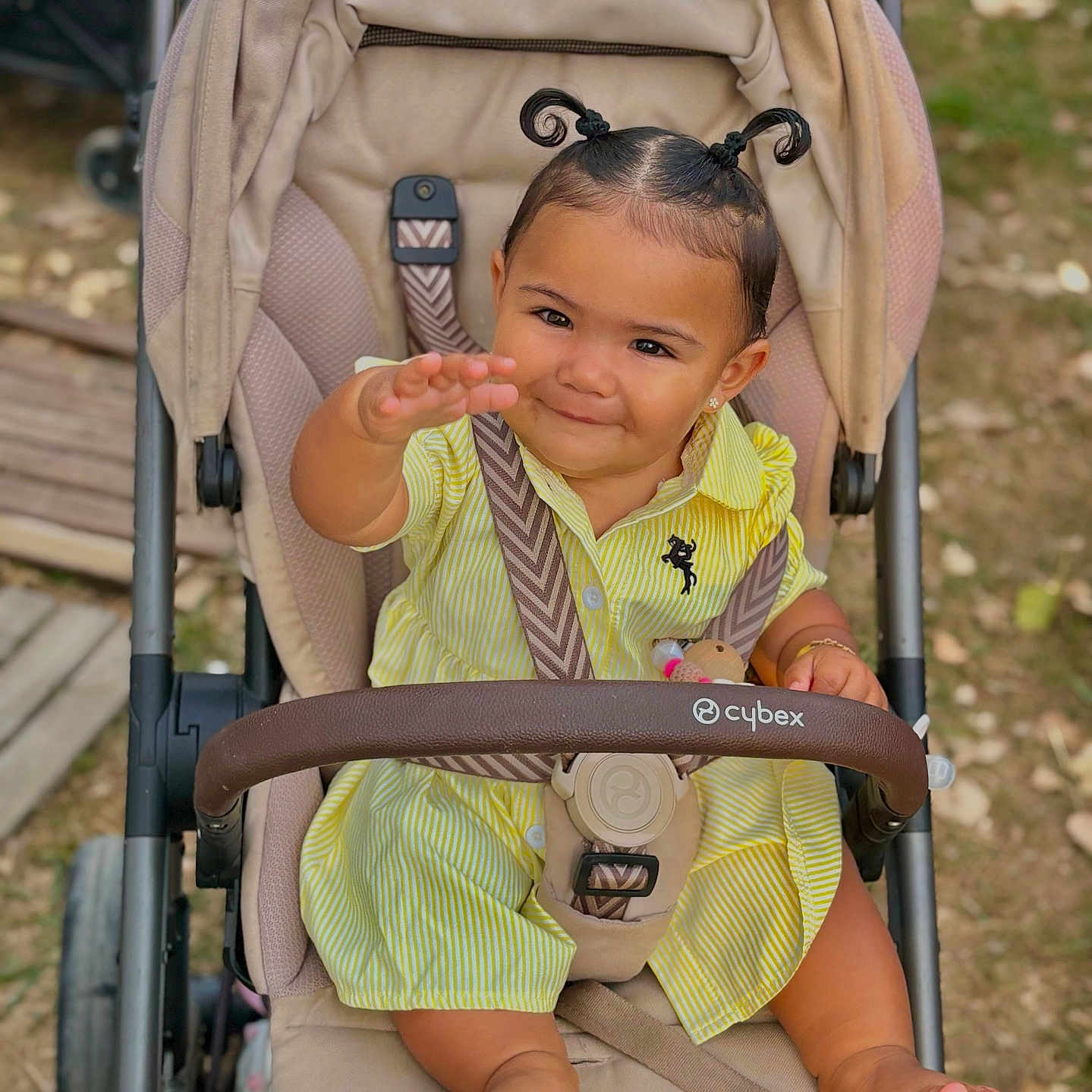 Méeva participe au concours pour gagner de l'argent avec cette photo : baby, baby_clothes, barefoot, child, cute, cute_expression, daylight, hair_pigtails, happy, infant, outdoor, park, person, playful, seat_belt, sitting, smiling, stroller, toddler, yellow_dress