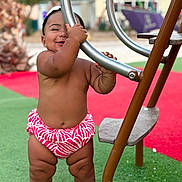 Méeva a rejoint le concours — aidez-le/la à gagner de superbes lots ! baby, barefoot, bracelet, child, clothing, fun, green, happy, headband, legs, metal, outdoor, person, play, playground, red, smiling, standing, summer, toy