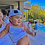 Méeva a rejoint le concours — aidez-le/la à gagner de superbes lots ! baby, child, person, cap, hat, outdoor, pool, swimwear, sunny, daylight, adult, holding, smile, people, conversation, blue_sky, trees, lounge_chair, bracelet, building