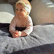 Blum Lydia participe au concours pour gagner de l'argent avec cette photo : baby, child, headband, blanket, couch, curious, expression, face, hands, indoors, light, looking_up, pink_clothing, plush, portrait, rosy_cheeks, sitting, soft_light, toddler, young_child