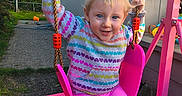 Vanessa is registered to the contest to win money with this photo: child, toddler, swing, pink_swing, outdoor, playground, hoodie, colorful_clothing, smiling, happy, blue_eyes, rope, grass, house, sunlight, backyard, play, toy, person, daylight