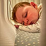 baby, sleeping, crib, pajamas, giraffe_print, blanket, mesh, infant, face, peaceful, child, closeup, soft_lighting, indoors, cute, resting, young, bed, comfort, toddler