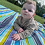 Finley is registered to the contest to win money with this photo: baby, blanket, blue_eyes, child, clothing, cute, daylight, face, grass, greenery, infant, nature, outdoor, park, person, photography, playing_child, portrait, smiley_face_pattern, striped_blanket