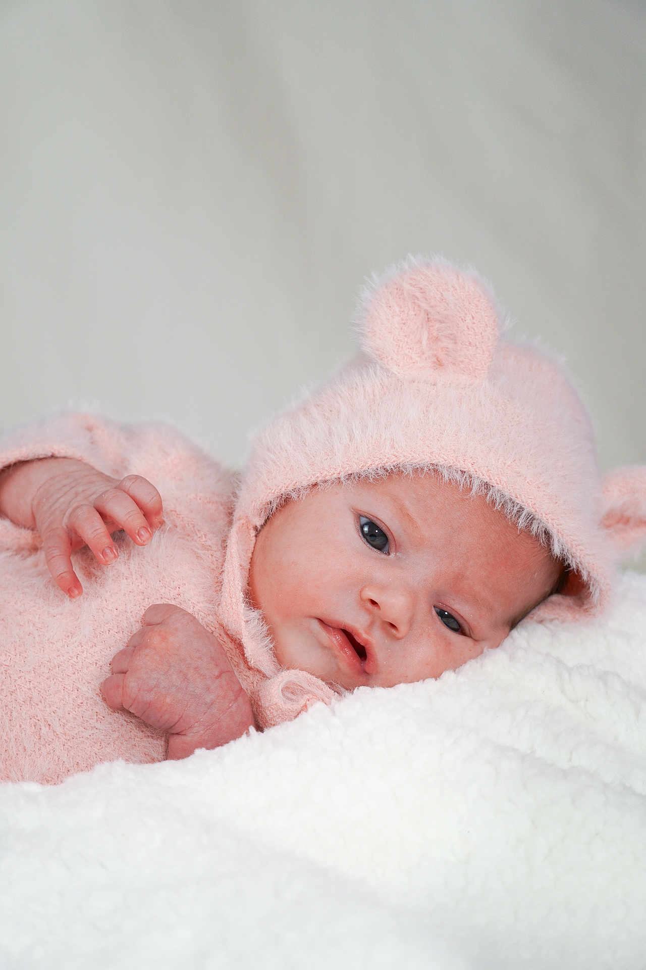 Denissa participe au concours pour gagner de l'argent avec cette photo : baby, infant, pink_clothing, hat, bear_ears, blanket, soft_texture, lying_down, close_up, face, hand, cute, newborn, warm, cozy, portrait, sleepy, child, indoors, toddler