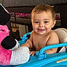 baby, smile, walker, toy, plush_toy, indoor, child, happy, face, person, playpen, blue, pink, cute, sitting, infant, furniture, home, young_child, expression