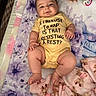 baby, infant, child, smiling, lying_down, portrait, face, eyes, onesie, clothing, blanket, floral_blanket, plush_toy, pacifier, nursery, cozy, indoor, bed, happy, resting
