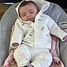 baby, infant, sleeping, portrait, child, indoors, car_seat, blanket, white_clothing, hooded_outfit, striped_socks, pink_blanket, cushion, seated, peaceful, cozy, nursery, animal_pattern, face, photography
