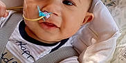 Kamari joined the competition — help win amazing prizes! baby, blanket, car_seat, child, closeup, clothing, comfort, cute, expression, eyes, face, head, indoors, infant, medical_equipment, nasal_tube, person, sitting, straps, young