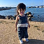 Lyvia participe au concours pour gagner de l'argent avec cette photo : toddler, child, pacifier, denim_outfit, white_lace, shoes, waterfront, rocks, gravel, shadow, sunlight, outdoor, blue_sky, boats, harbor, hair, wind, person, summer, casual_clothing