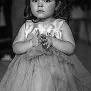Lyvia participe au concours pour gagner de l'argent avec cette photo : child, girl, tulle_dress, dress, portrait, black_and_white, curly_hair, expression, hands, standing, indoor, young_child, cute, innocent, face, eyes, hair, clothing, person, photo