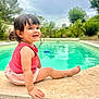 Lyvia participe au concours pour gagner de l'argent avec cette photo : toddler, child, smiling, pool, water, outdoor, greenery, trees, sky, cloudy, pink_clothing, bracelet, sitting, happy, cute, portrait, young_child, daylight, nature, relaxing
