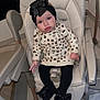 baby, baby_girl, black_clothing, bow, child, cozy, curious_expression, cute, floor, footwear, furniture, headband, high_chair, indoor, infant, leopard_print, person, seat, small_hand, tights
