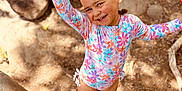 Dorothy joined the competition — help win amazing prizes! child, smiling, outdoor, sunlight, rocks, dirt, swimsuit, floral_pattern, shoes, play, happy, waving, toy_shovel, toy_mold, nature, summer, cute, playground, person, sand