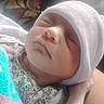 Savanna is registered to the contest to win money with this photo: newborn, baby, sleeping, infant, portrait, close_up, face, knit_cap, hat, floral_clothing, blanket, bundled, cozy, peaceful, indoors, soft_light, resting, arms, person, family