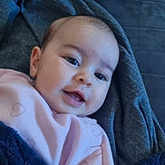 Alara is registered to the contest to win money with this photo: baby, blanket, child, closeup, cozy, cute, expression, eyes, face, happy, head, indoors, infant, mouth, pink_clothing, portrait, skin, smile, soft, warm
