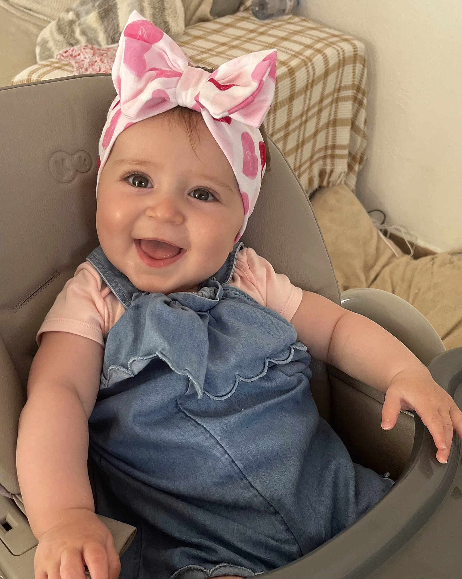 Magda a rejoint le concours — aidez-le/la à gagner de superbes lots ! baby, child, smiling, happy, headband, bow, denim_dress, high_chair, indoor, cute, toddler, person, face, skin, arm, furniture, seat, clothing, infant, portrait