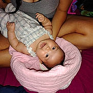 Nahanni is registered to the contest to win money with this photo: baby, infant, person, braid, gray_tank_top, pink_blanket, smile, skin, arm, hand, indoor, bed, clothing, face, happy, lying_down, holding, cute, young_child, cozy