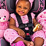 baby, baby_clothes, blanket, bow, car_seat, child, close_up, crocs, food, happy, headband, indoors, infant, pink, portrait, sandwich, seatbelt, smiling, teddy_bear, toys