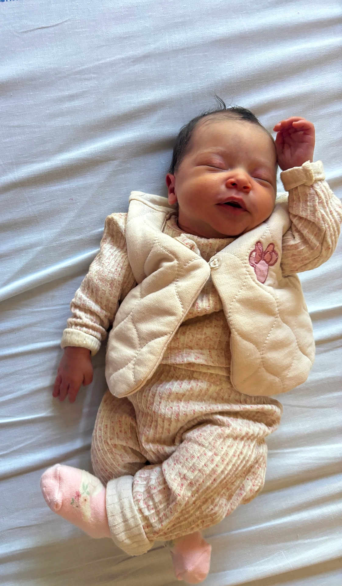 Kléïs a rejoint le concours — aidez-le/la à gagner de superbes lots ! baby, sleeping, infant, soft, cozy, clothing, pastel_colors, white_sheet, hand, smile, peaceful, cute, portrait, child, newborn, resting, face, sock, vest, bed
