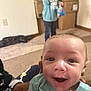 Otis joined the competition — help win amazing prizes! baby, blue_shirt, blurred_background, box, carpet, child, clothing, face, hand, happy, holding, home, indoor, person, person_holding_baby, room, sitting, smiling, snack, young_child