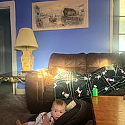 Otis joined the competition — help win amazing prizes! baby, blanket, car_seat, carpet, child, couch, cozy, curious, floor, furniture, home, indoor, lamp, living_room, pattern, person, plaid, sunlight, table, toy