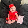 baby, infant, red_dress, headband, flower, couch, pillow, milestone_card, smiling, sitting, indoors, child, cute, happy, portrait, person, feet, skin, clothing, home