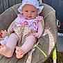 Katie is registered to the contest to win money with this photo: baby, child, infant, hat, bib, baby_rocker, giraffe_pattern, toy, outdoor, grass, face, legs, feet, pink_clothing, smile, sunhat, cute, garden, seat, person