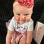 Katie joined the competition — help win amazing prizes! baby, infant, child, pink_headband, flower_headband, white_shirt, pink_skirt, milestone_card, six_months_old, sitting, couch, dark_background, cheerful, cute, portrait, indoors, happy, smiling, person, closeup