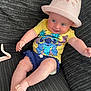 Katie joined the competition — help win amazing prizes! baby, child, hat, pink_hat, yellow_shirt, cartoon_character, blue_shorts, barefoot, couch, textured_couch, smiling, happy, playful, indoor, person, infant, cute, clothing, relaxed, reaching_out